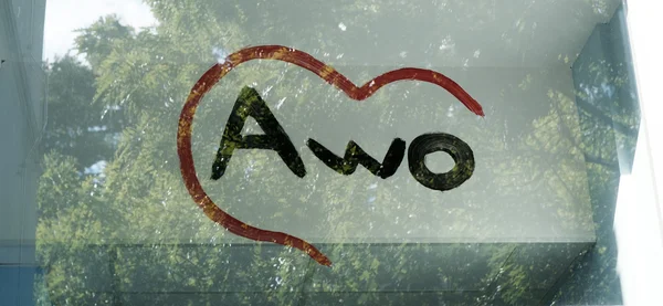 Handgemalter AWO-Schriftzug mit Herz durch ein Fenster betrachtet