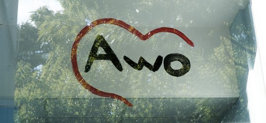 Handgemalter AWO-Schriftzug mit Herz durch ein Fenster betrachtet