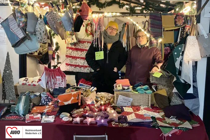 Das Foto zeigt die beiden Mitarbeitenden an dem AWO Weihnachtsmarktstand.