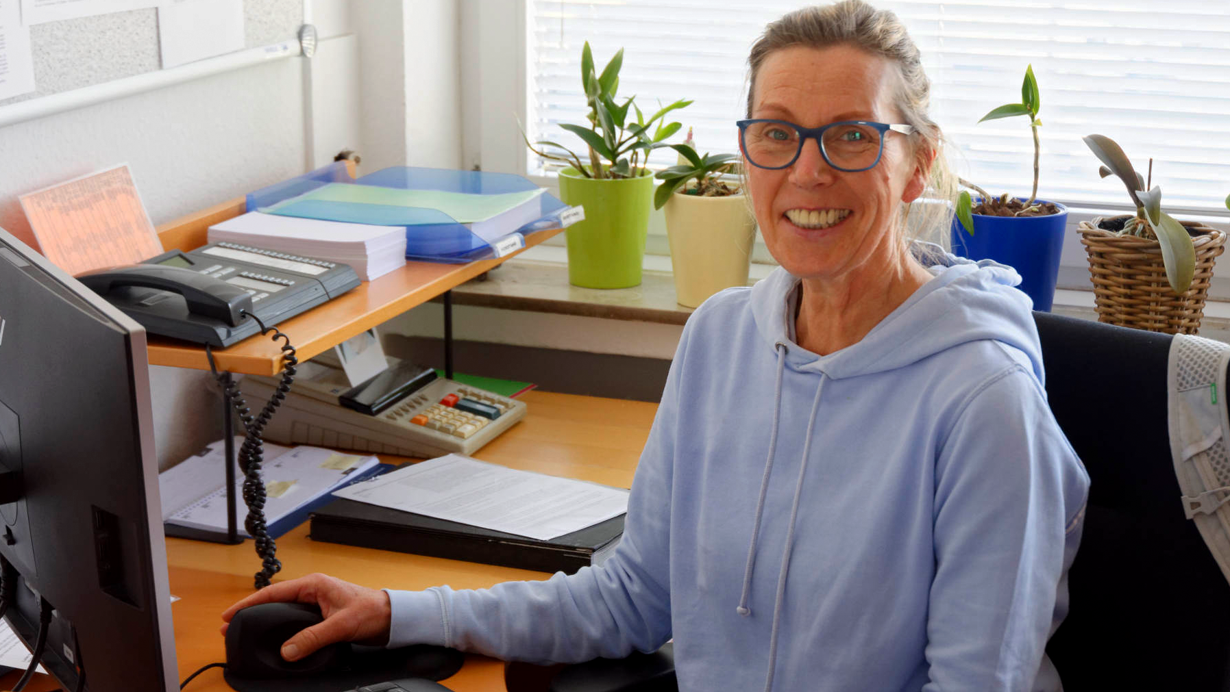 Das Foto zeigt ein Portrait von Jutta Hessel an ihrem Schreibtisch