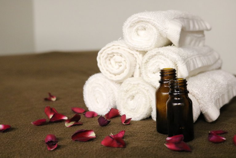 Das Foto zeigt Rosenblätter und Massagehandtücher (Bild von BrandeePember auf Pixabay)