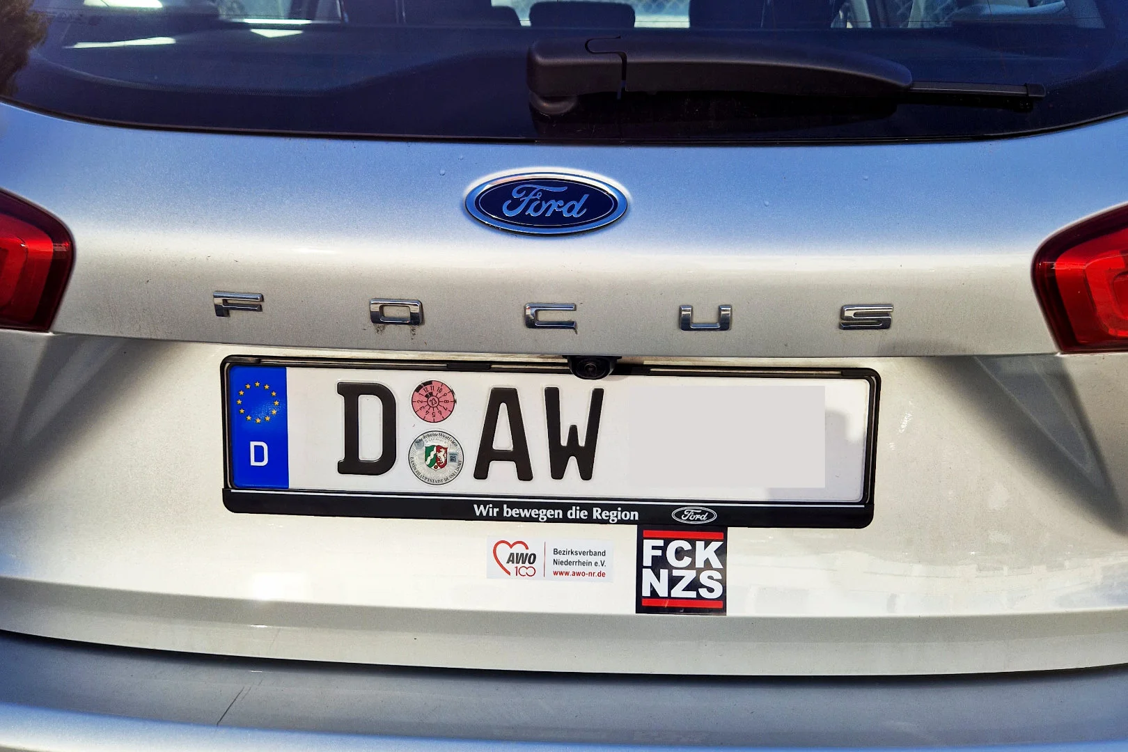 Das Foto zeigt einen Dienstwagen der AWO Niederrhein mit dem Aufkleber FCK NZS