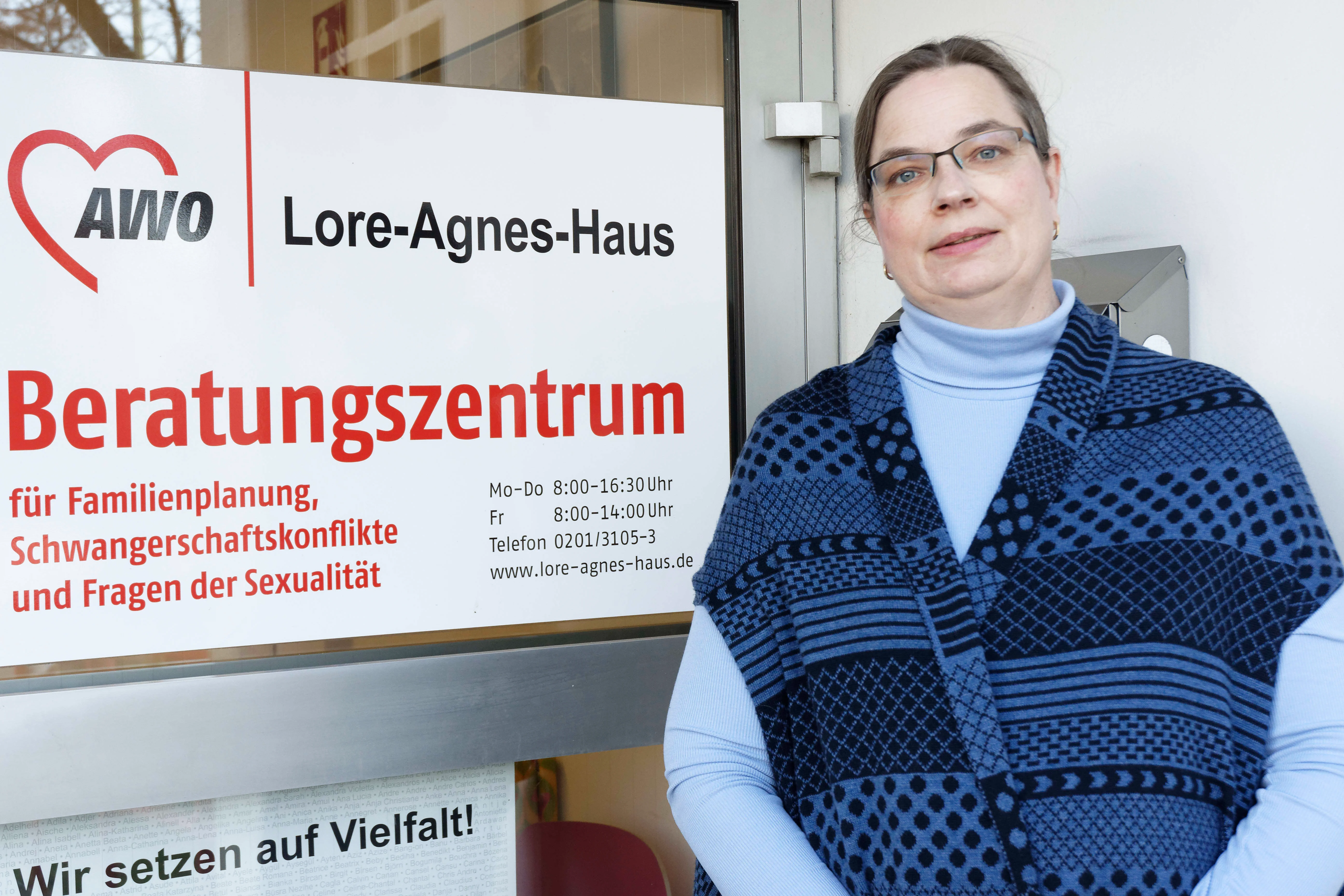 Das Foto zeigt ein Portrait von Nicola Völckel am Eingang des AWO Lore-Agnes-Hauses.