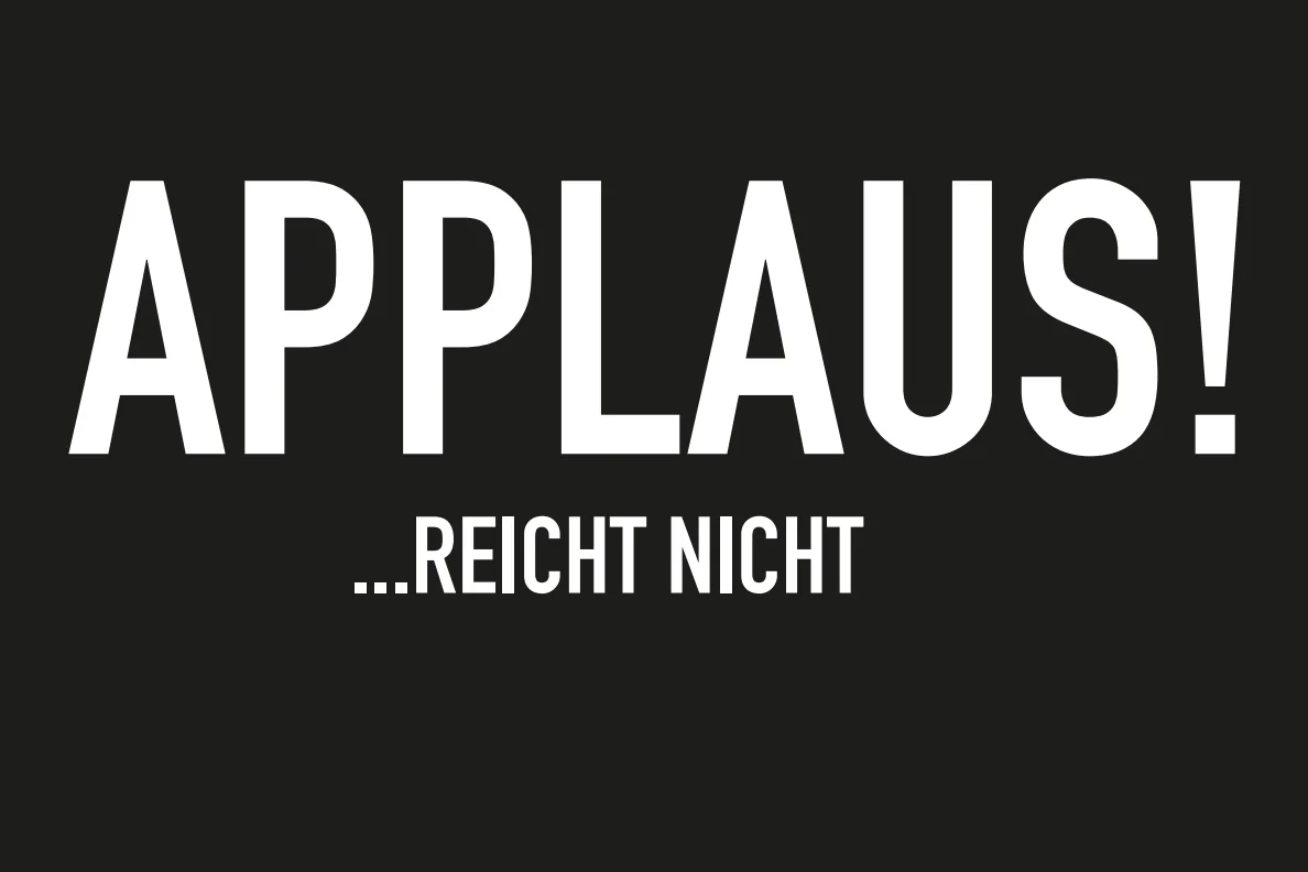 Das Foto zeigt weiß auf schwarz den Text: Applaus! ...reicht nicht