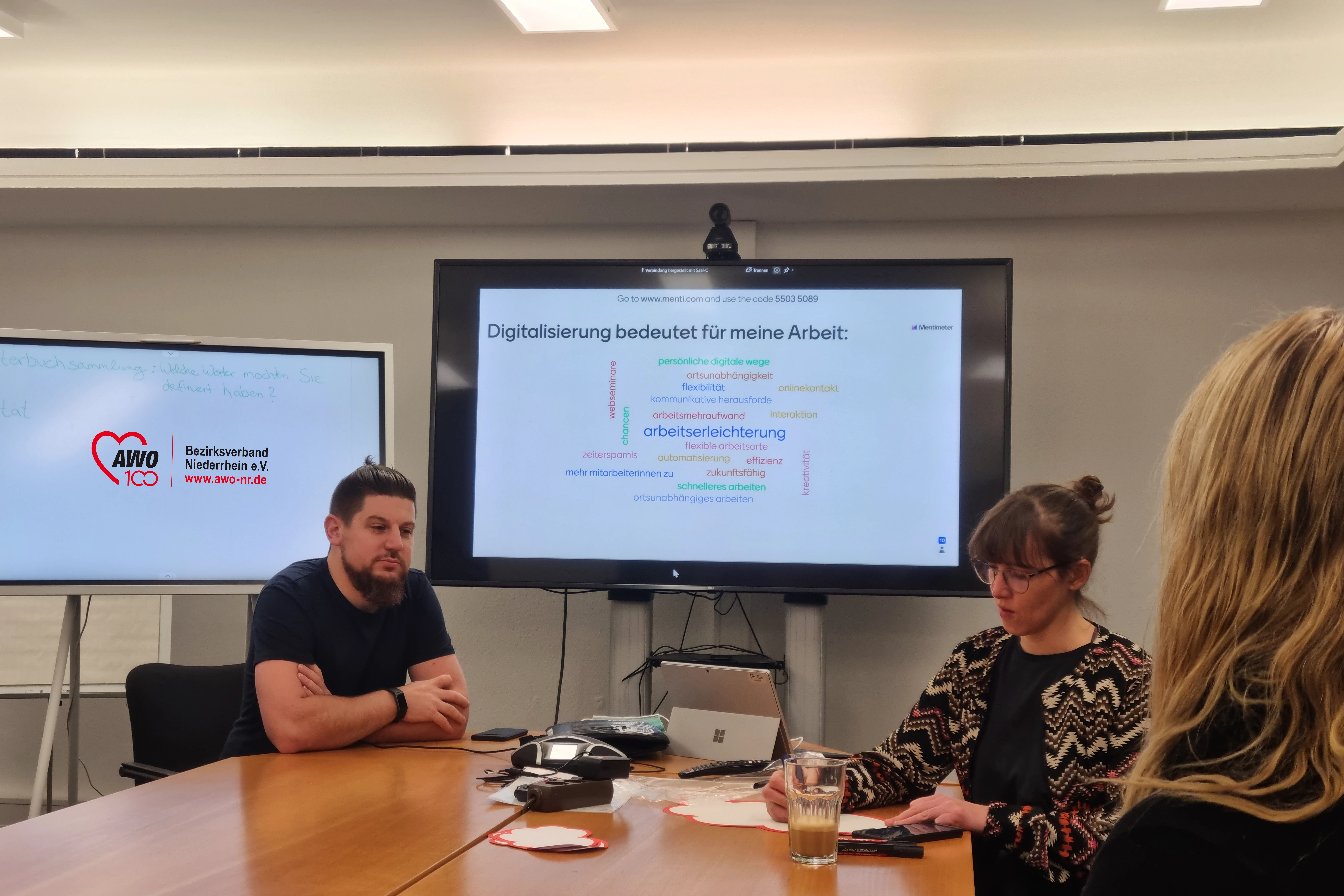 Das Foto zeigt Pascal Jabusch unter andere Kolleg*innen bei einer Besprechung zur Digitalisierung.