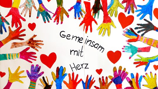 Gemalte Kinderhände zeigen auf den Claim "Gemeinsam mit Herz"