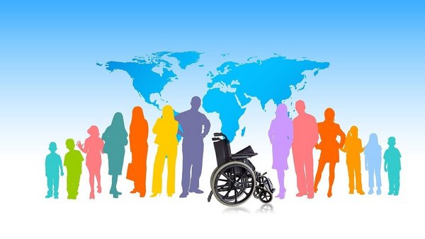 Auf dem Bild sind bunte Silhouetten von Menschen unterschiedlichen Alters zu sehen, die nebeneinander stehen. In der Mitte steht ein leerer Rollstuhl, im Hintergrund ist eine stilisierte Weltkarte vor blauem Himmel dargestellt.