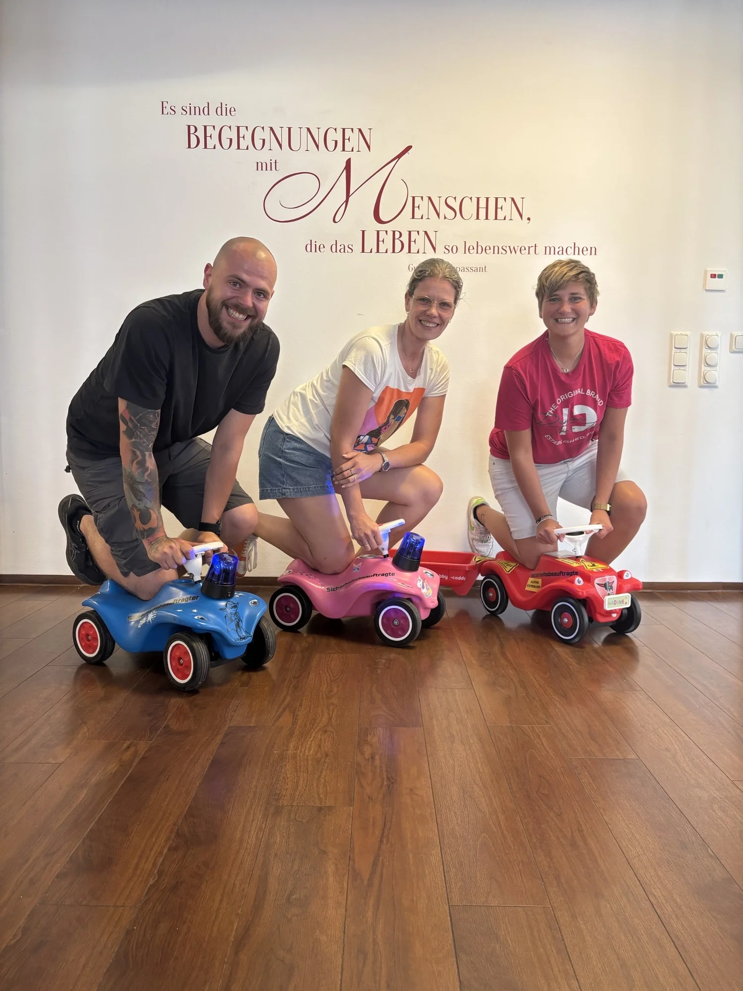 Das Bild zeigt die Kolleg*innen auf den sogenannten Dienstfahrzeuge (Bobbycars).