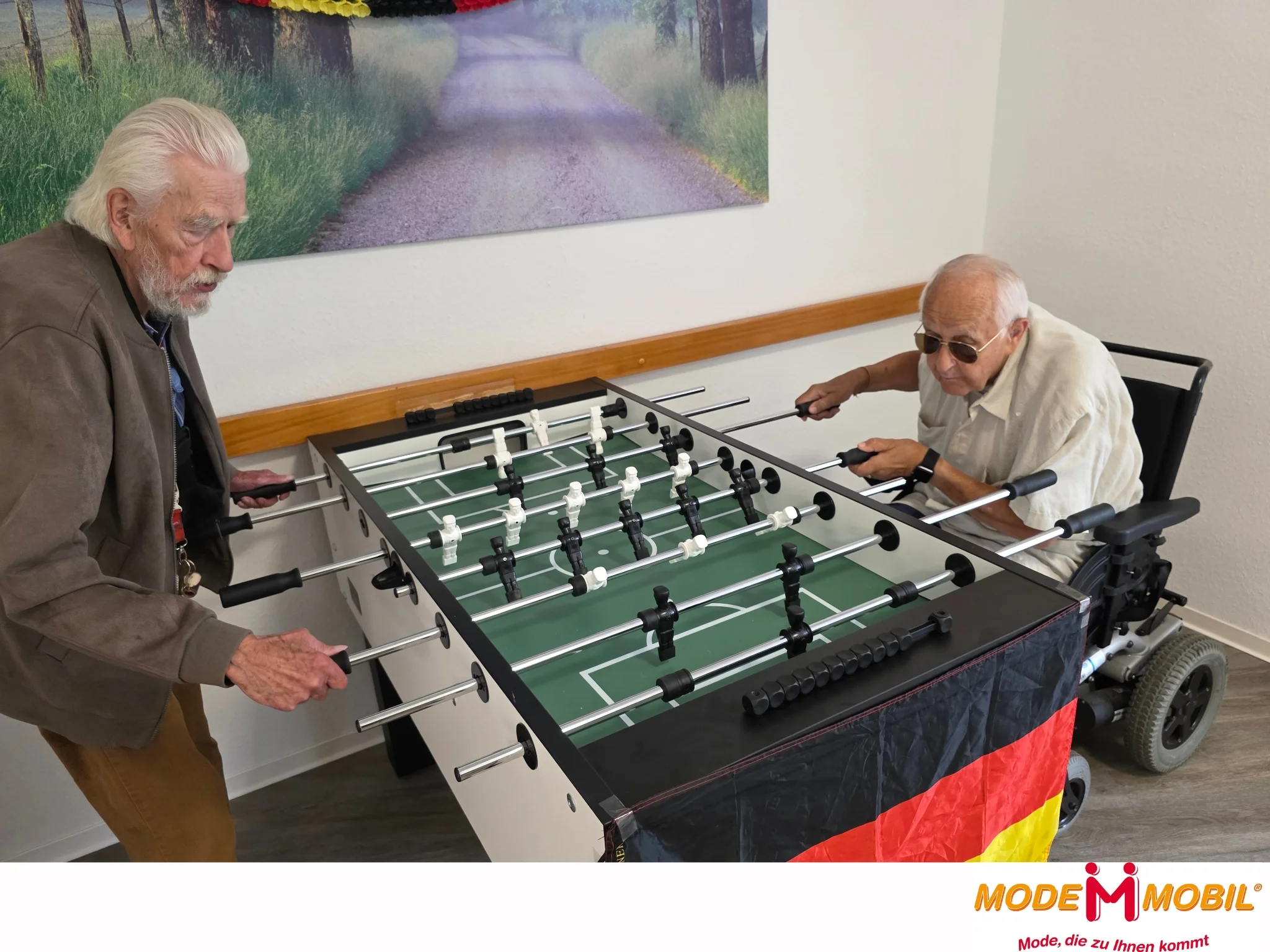 Auf diesem Bild sieht man zwei Bewohner am Kickertisch.