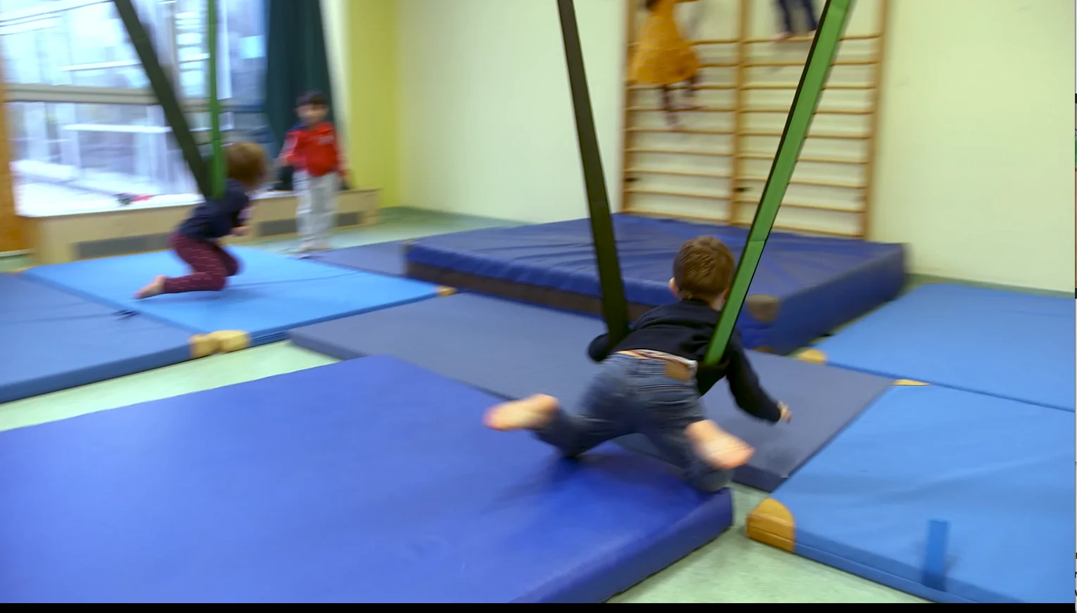 Das Foto zeigt ein Screenshot aus dem Film. Zusehen ist ein Kind in einer Hängeschaukel