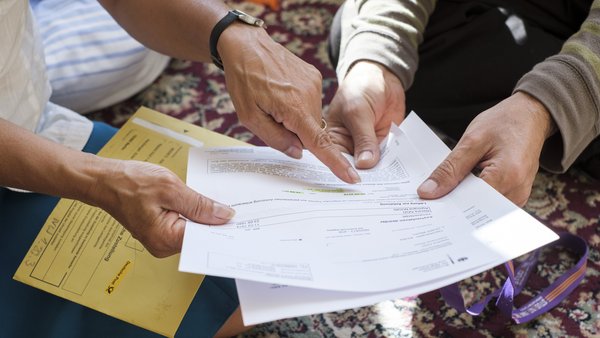 Zwei Personen betrachten ein behördliches Schreiben Zwei Personen betrachten ein behördliches Schreiben