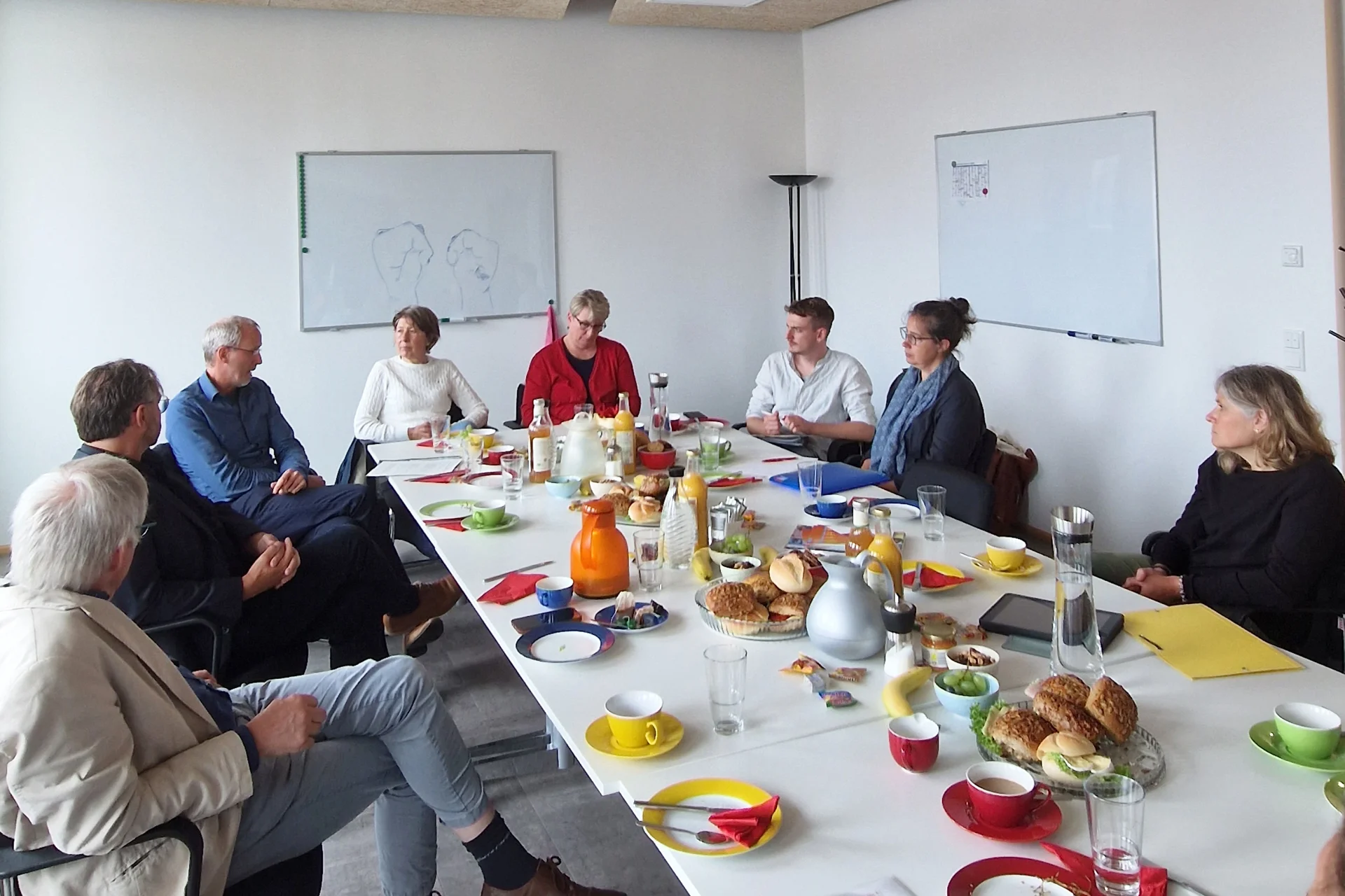 Das Foto zeigt die Gesprächsteilnehmenden in einem Besprechungsraum