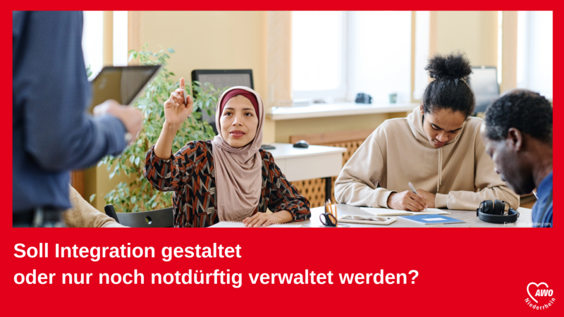 Auf dem Foto ist eine Szene aus einem Bildungskontext zu sehen. Drei Personen sitzen an einem Tisch, offenbar in einem Klassenzimmer oder Kursraum: Eine Frau in der Mitte, die ein Kopftuch trägt, hat den Finger gehoben, als wolle sie eine Frage stellen oder sich melden. Zwei weitere Personen (ein junger Mann und ein älterer Mann) sitzen daneben und schreiben oder lesen konzentriert. Eine vierte Person (nur teilweise im Bild sichtbar) scheint vorne zu stehen und eventuell zu unterrichten oder etwas zu erklären. Der Text im unteren Bereich des Bildes lautet: „Soll Integration gestaltet oder nur noch notdürftig verwaltet werden?“ In der Ecke rechts unten befindet sich das Logo der AWO Niederrhein (Arbeiterwohlfahrt) – einer sozialen Wohlfahrtsorganisation. Das Bild vermittelt den Eindruck eines Appells oder einer Kampagne zur aktiven Gestaltung von Integrationsprozessen, anstatt diese lediglich zu verwalten.
