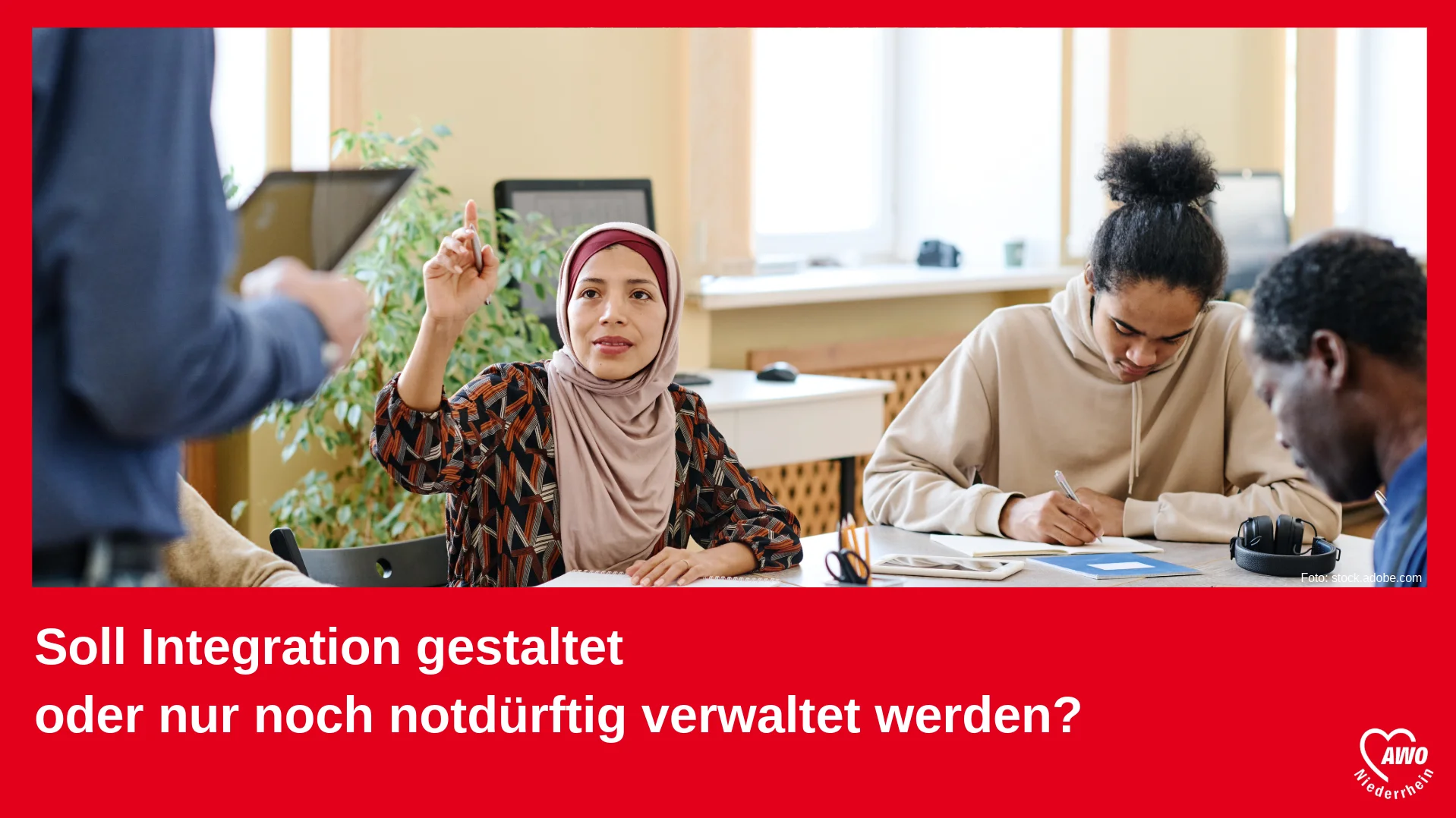 Auf dem Foto ist eine Szene aus einem Bildungskontext zu sehen. Drei Personen sitzen an einem Tisch, offenbar in einem Klassenzimmer oder Kursraum: Eine Frau in der Mitte, die ein Kopftuch trägt, hat den Finger gehoben, als wolle sie eine Frage stellen oder sich melden. Zwei weitere Personen (ein junger Mann und ein älterer Mann) sitzen daneben und schreiben oder lesen konzentriert. Eine vierte Person (nur teilweise im Bild sichtbar) scheint vorne zu stehen und eventuell zu unterrichten oder etwas zu erklären. Der Text im unteren Bereich des Bildes lautet: „Soll Integration gestaltet oder nur noch notdürftig verwaltet werden?“ In der Ecke rechts unten befindet sich das Logo der AWO Niederrhein (Arbeiterwohlfahrt) – einer sozialen Wohlfahrtsorganisation. Das Bild vermittelt den Eindruck eines Appells oder einer Kampagne zur aktiven Gestaltung von Integrationsprozessen, anstatt diese lediglich zu verwalten.