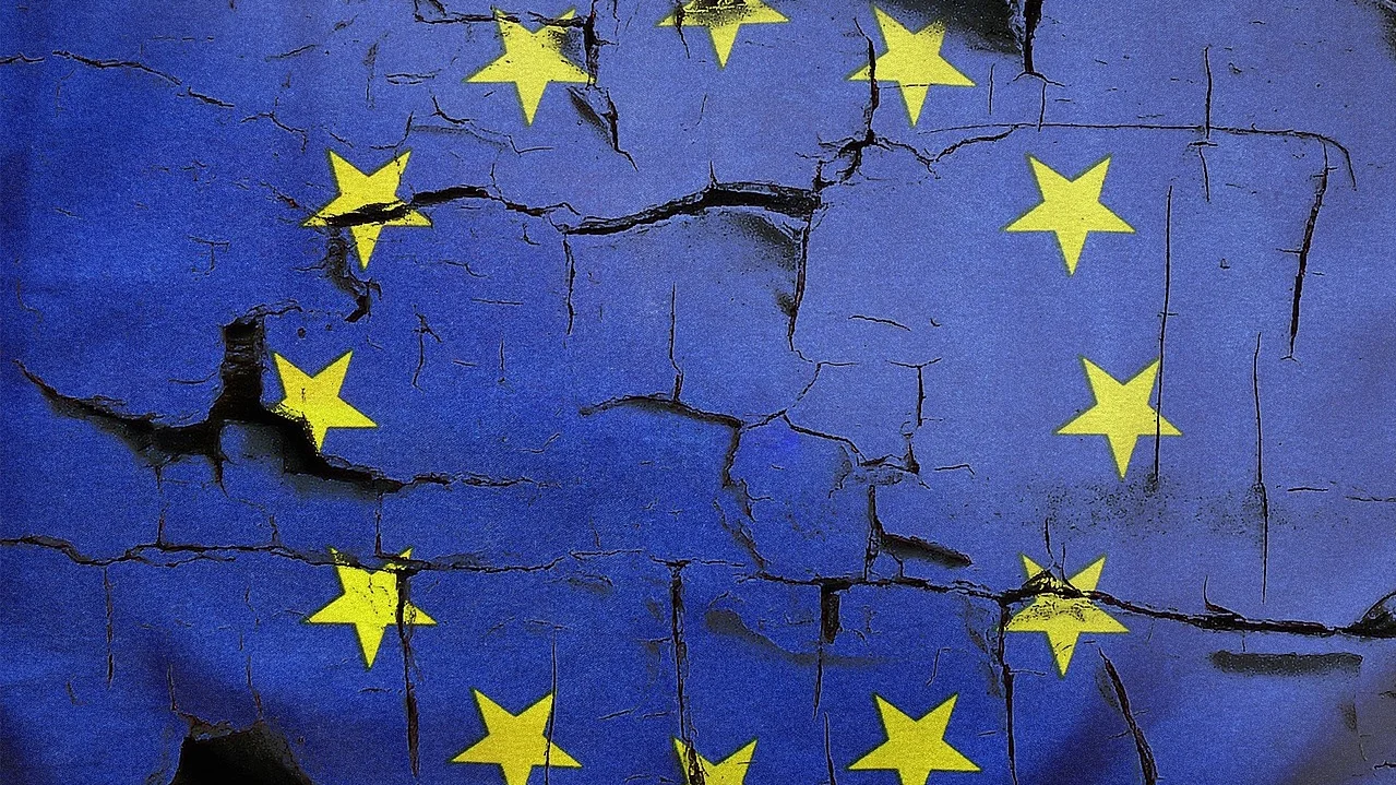 Auf dem Bild ist die Flagge der Europäischen Union zu sehen, deren blaue Fläche und gelbe Sterne stark rissig und wie aufgebrochen dargestellt sind.