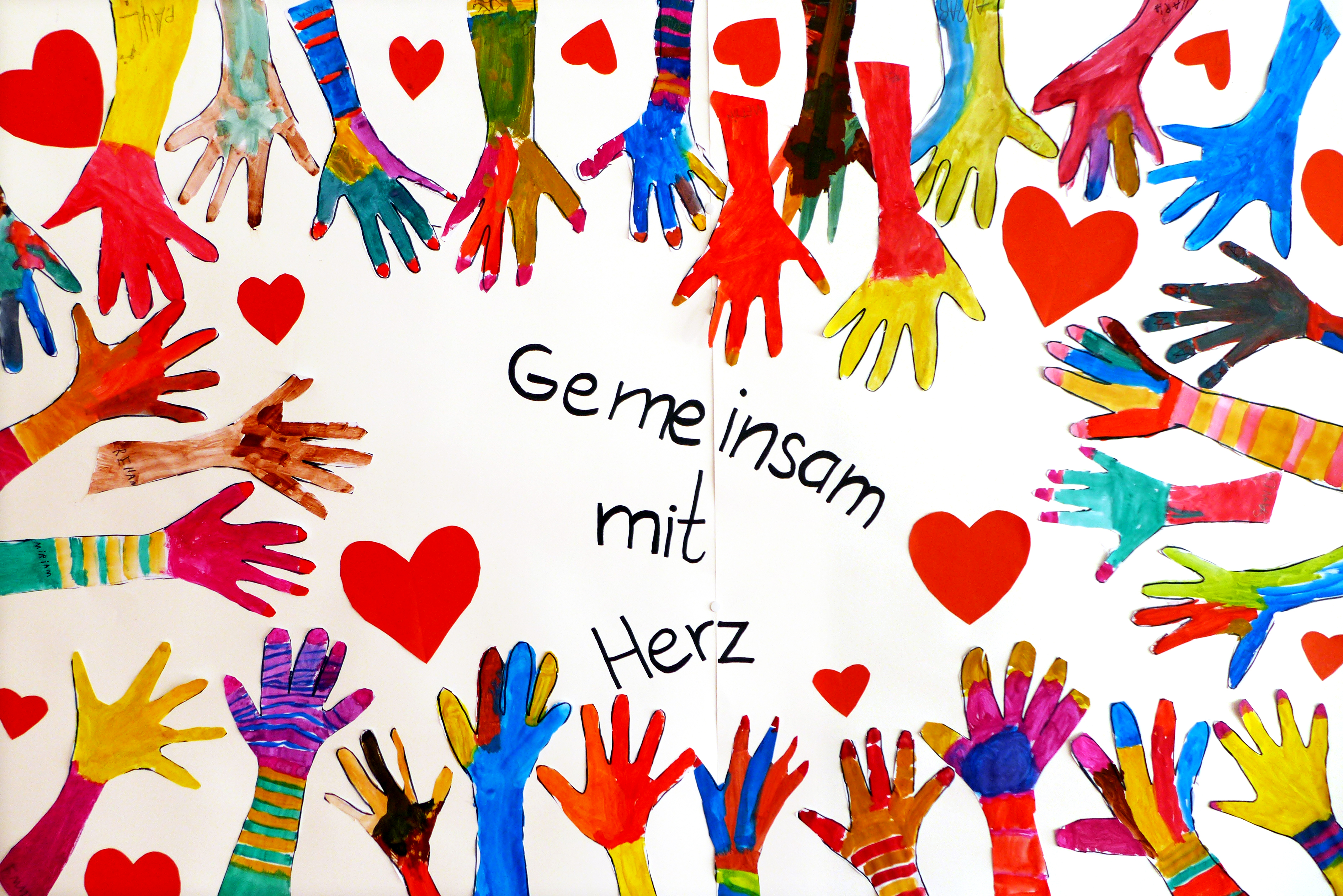 Gemalte Kinderhände zeigen auf den Claim "Gemeinsam mit Herz"
