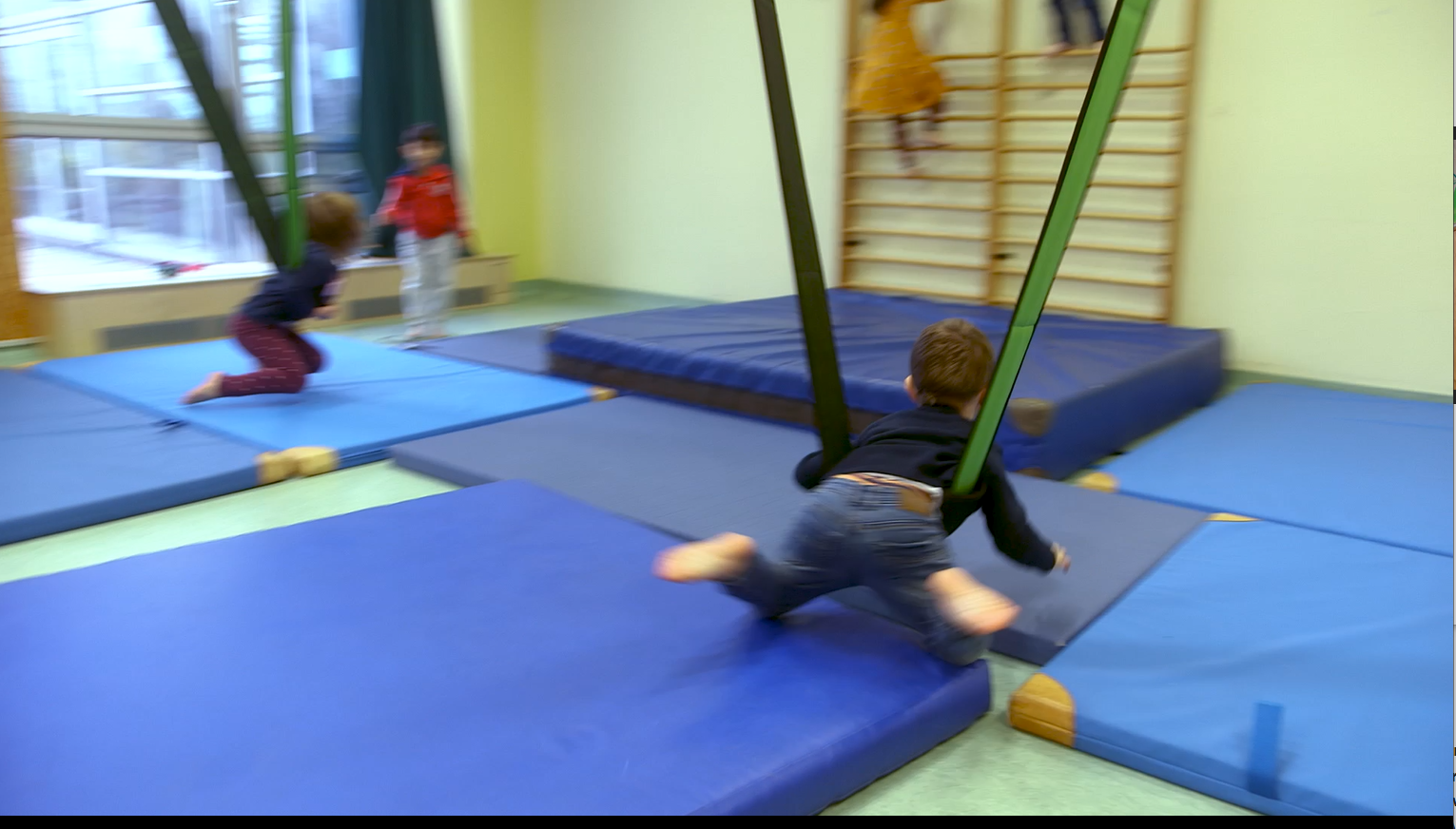 Das Foto zeigt ein Screenshot aus dem Film. Zusehen ist ein Kind in einer Hängeschaukel