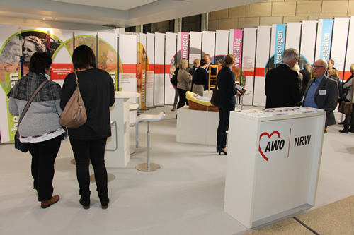 Besucher*innen schauen sich interessiert die AWO Ausstellung an